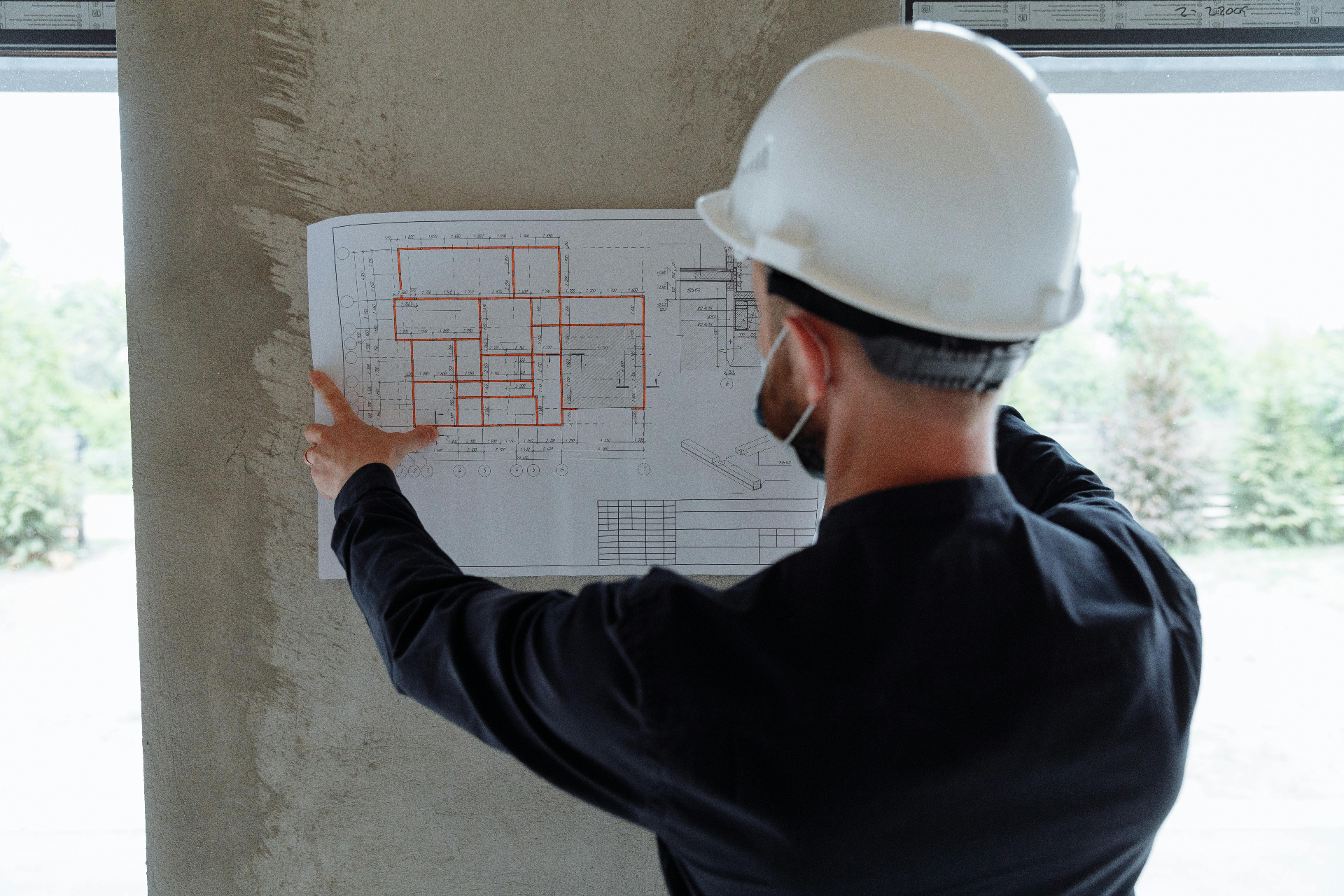 Engineer reviewing a construction blueprint on site